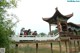 A group of people standing on top of a wooden bridge.