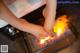 A woman's feet on a stove with flames coming out of it.