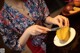 A woman cutting a mango with a knife. 