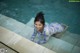 A woman in a blue and purple bathing suit in a pool.