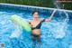 A woman in a black bikini holding an inflatable ring in a pool.