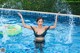 A woman in a black bikini standing in a swimming pool.