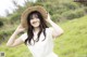 A woman in a white dress and a straw hat.