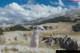 A woman in a white dress standing on top of a mountain.