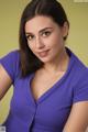 A woman in a purple shirt posing for a picture.